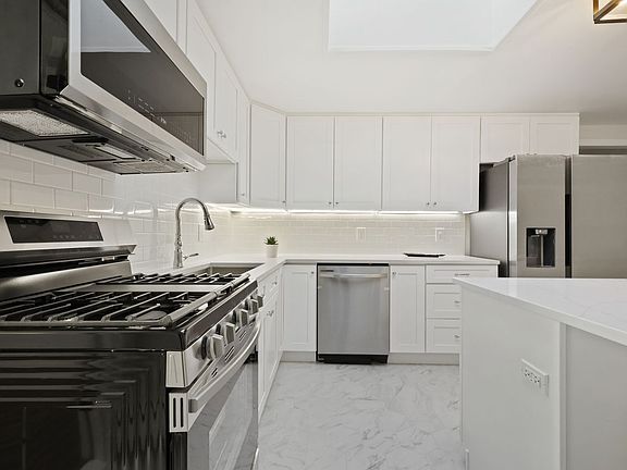 Stainless steel appliances, quartz countertops, and under cabinet lighting