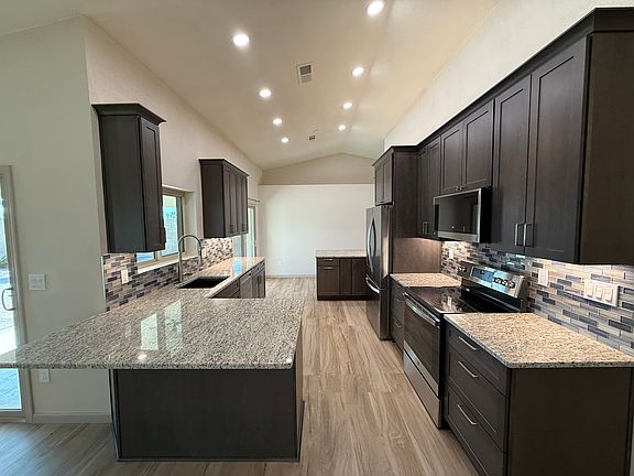 Kitchen from dining area with countertop overhang with room for stools