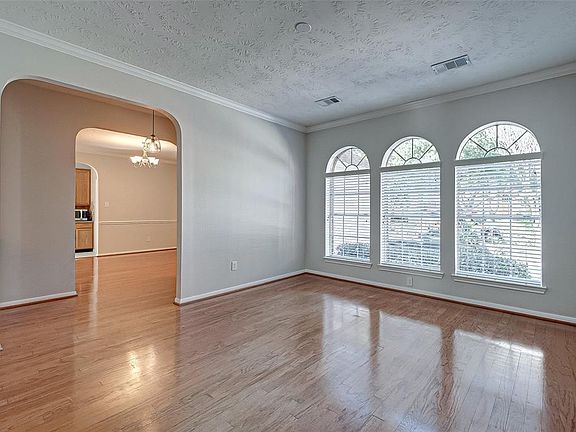 Spacious formal living room or study with ample natural lighting and elegant hard wood flooring.