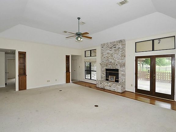 THE TRANSOM WINDOWS IN THE LIVING ROOM LET IN LOTS OF NATURAL LIGHT. THE DOORS LEAD TO A HUGE COVERED PATIO.