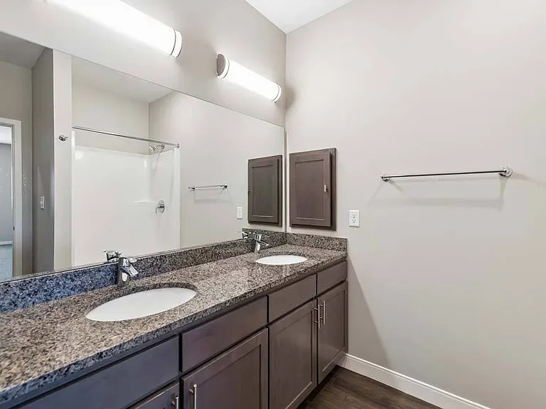 Begin and end each day in a thoughtfully designed bathroom featuring a dual-sink vanity, ample counter space, and refined finishes that elevate your daily routine.