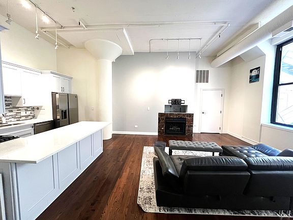 Living Room with 13-foot concrete ceilings; Newly resurfaced hardwood floors