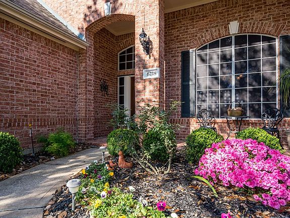 Wander up to the sidewalk amongst the pretty blooming foliage, and take a seat on the covered front porch! This is the perfect spot to enjoy your morning coffee!