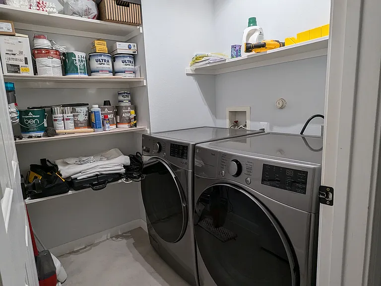 Utility room with brand new washer-dryer and ample space for storage
