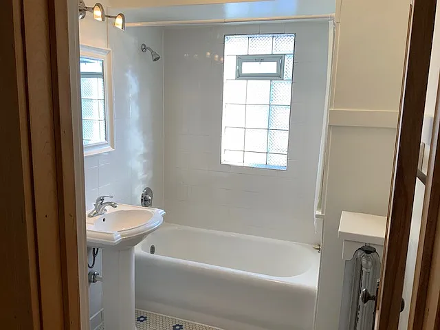 Bathoom with tiled floors and large bahtub/shower.