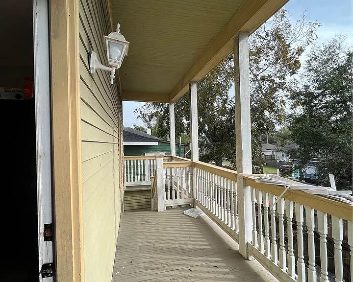 Back porch with covered seating space and neighborhood views.