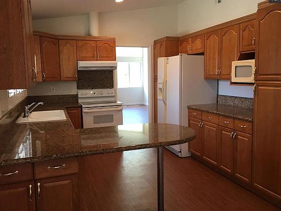 Kitchen with dishwasher, microwave, side-by-side fridge, oven/cooktop. Lots of storage.