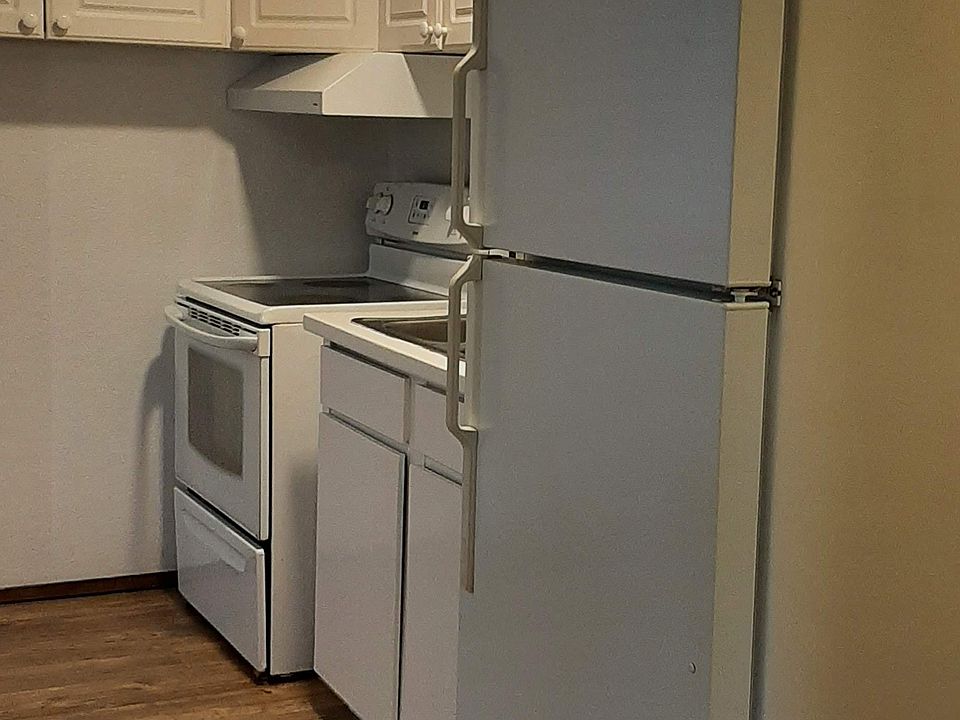 Kitchen has range, refrigerator and sink. Upper cabinets provide lots of useful storage space.