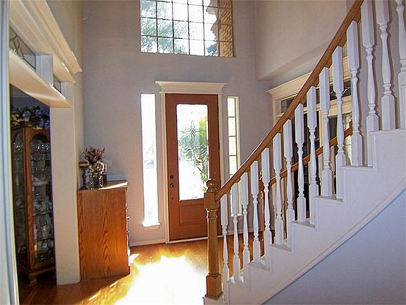 At the front entry, you will be greeted with wood floors and a sweeping staircase.