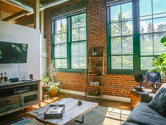 The living room provides an abundance of natural light, particularly in the morning.