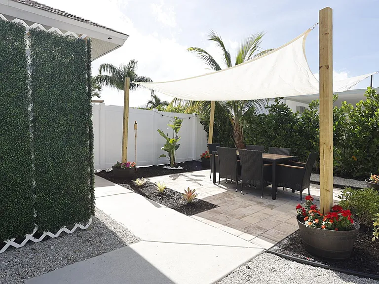 The outdoor dining area for up to 6 people sits under a sun screen for those relaxing meals in the back yard.