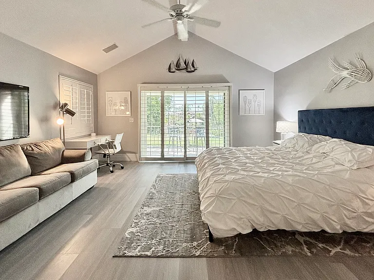 Upstairs primary bedroom with king bed and balcony overlooking the lake