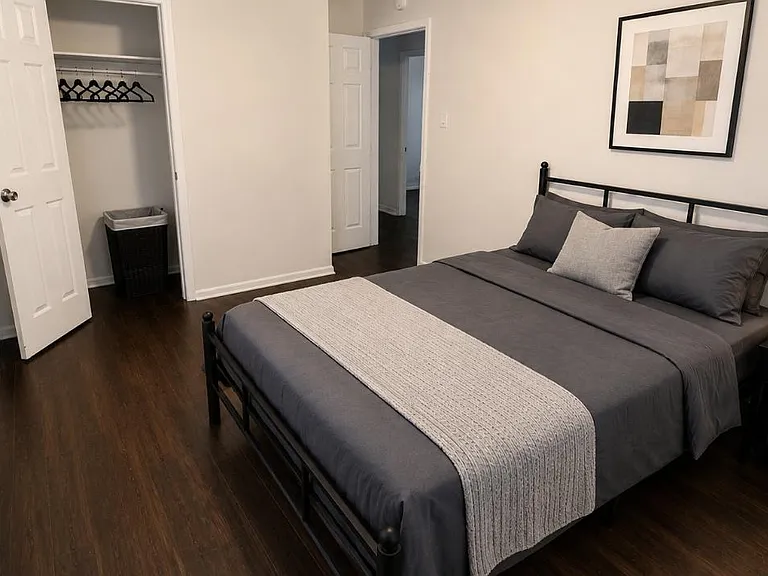 Well-appointed bedroom with a full bed, nightstand lighting, and a closet for hanging storage, plus window blinds.