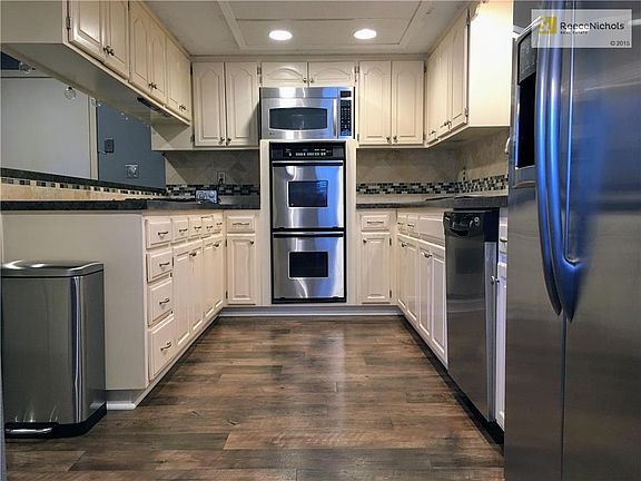 Kitchen View. Features: New Flooring, New Custom Tile Backsplash, New Interior Paint, All Stainless Steel Appliances Stay Including Built-In Gas Stovetop, Double Oven, French Door Refrigerator, Dishwasher, & Microwave.