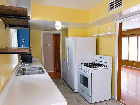Bright kitchen has lots of windows, room for a breakfast nook, washer and dryer, refrigerator and new gas range. There is also a pantry and a door that leads to the backyard.