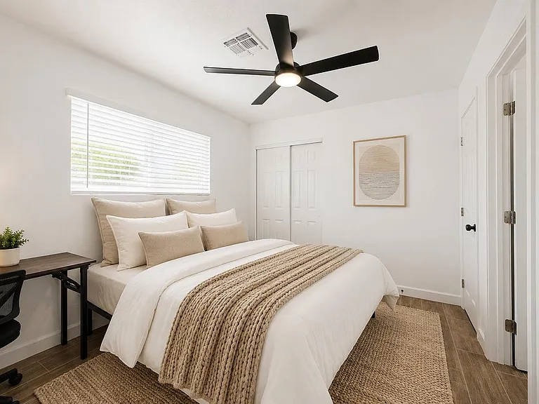 Well-appointed bedroom with a full bed, desk workspace, ceiling fan, and closet storage, plus window blinds for privacy.