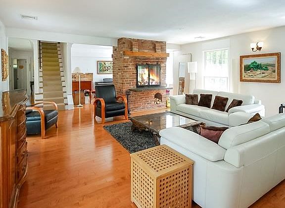 Living room w/ fireplace open to sitting room and dining room