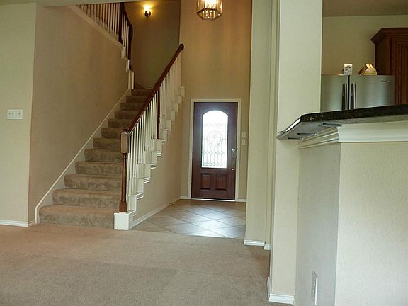 Tiled entry with another view of the front door and stairway leading to the second floor.