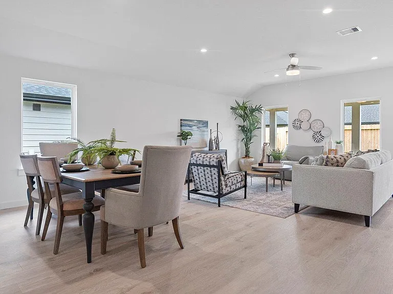 Open-concept living and dining area with ample seating, recessed lighting, ceiling fan, and easy access to the backyard.
