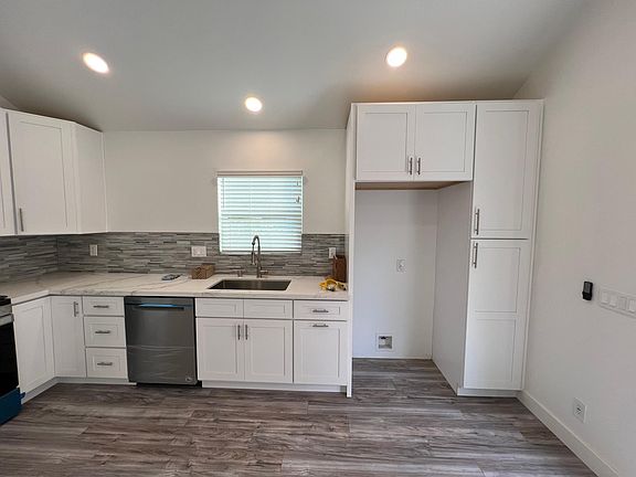 Kitchen with deep large sink and garbage disposal. Easy to clean tile backsplash and plenty of storage compartments