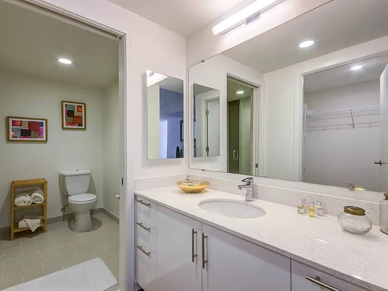 Experience comfort and elegance in this bathroom with a sleek quartz countertop, spacious vanity, and walk-in shower.