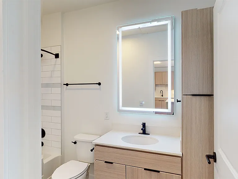 Apartment bathroom with wood-style flooring.
