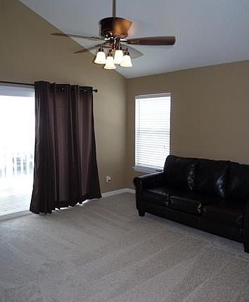 Vaulted living room with sliding door to balcony.