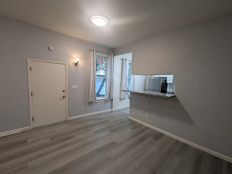 Front door and living room. New floor, new windows and curtains throughout.