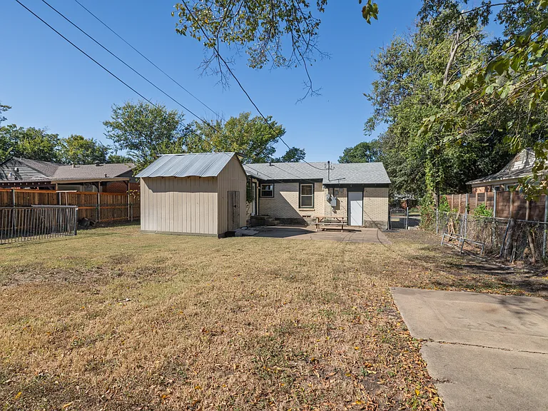 Spacious fenced backyard perfect for pets, games, or relaxing outdoors. Enjoy a picnic table, open lawn, and peaceful neighborhood views under the Texas sun.