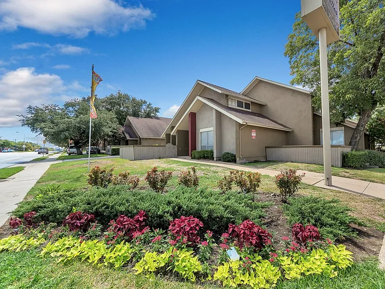 Beautifully landscaped community entrance with mature trees and manicured grounds