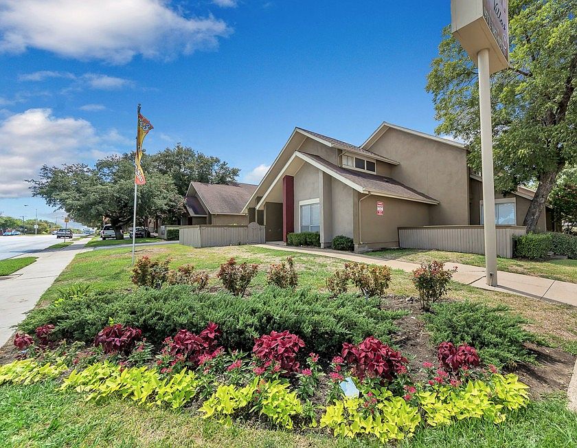 Beautifully landscaped community entrance with mature trees and manicured grounds