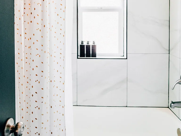 Full bathroom on main level with shower, bathtub, bidet, and plenty of towels.