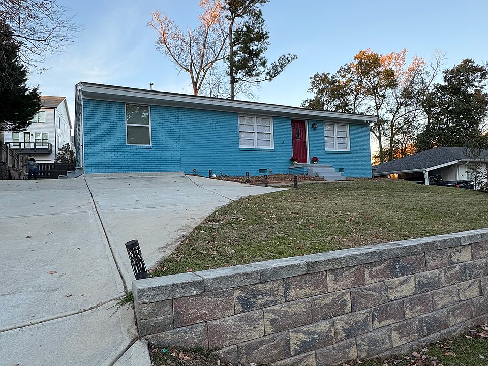 A striking blue brick facade with a bold red front door creates an inviting first impression. Freshly painted and nestled in a quiet cul-de-sac, this home stands out with its modern charm.