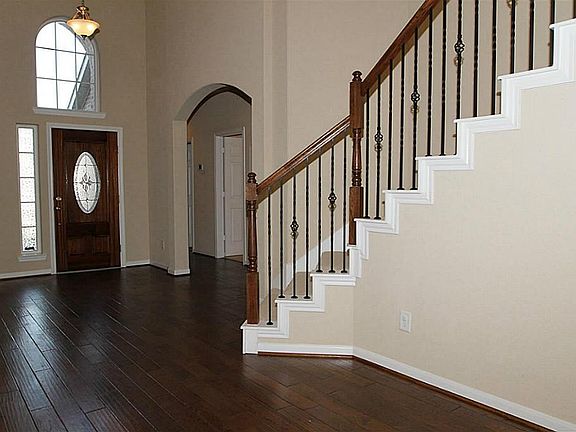 Grand 2 story entry and gorgeous hardwood flooring in entry, hallway, and dining room. Iron railings