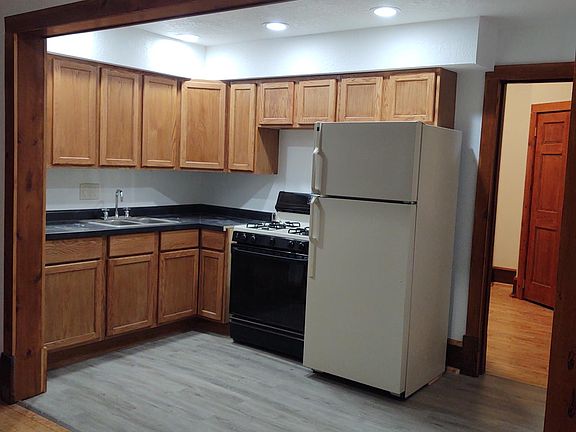 Beautifully remodeled kitchen with new cupboards, high-end plank flooring, and stove, refrigerator.