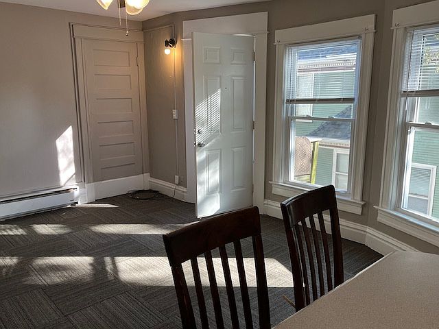 Beyond living room, breakfast bar and barstools are shown.