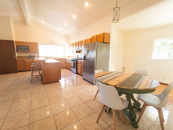 Open concept kitchen and dining area have a high ceiling.