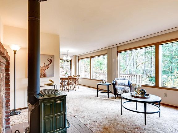 Here is the view of the dining room space and the forest beyond the windows.  It is off this side of the house where you'll find the creek.  It comes down the hill and has a lovely sound when the windows are open on a beautiful summer evening.