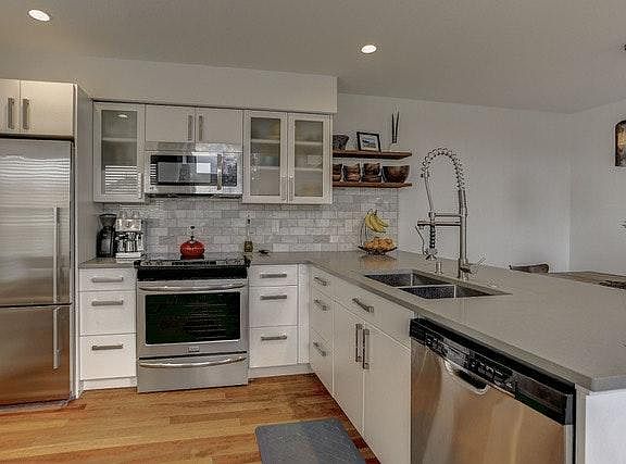 Open kitchen with high end stainless appliances and breakfast nook.