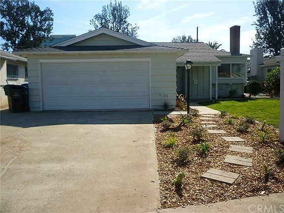 Cement driveway with stepping stones and some drought tolerant landscaping.