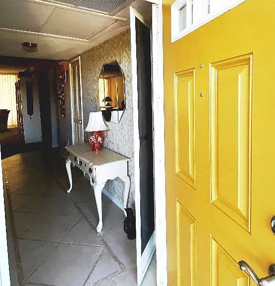 Entrance door stopped open to walkway. View through entrance hall with custom marble inlay porcelain tile flooring