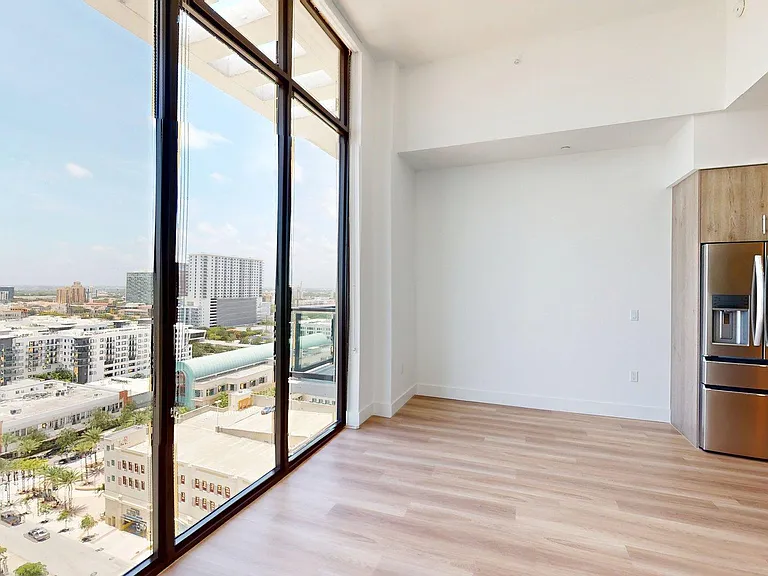 Apartment Kitchen with Stainless Steel Appliances, Dining and Living Room.