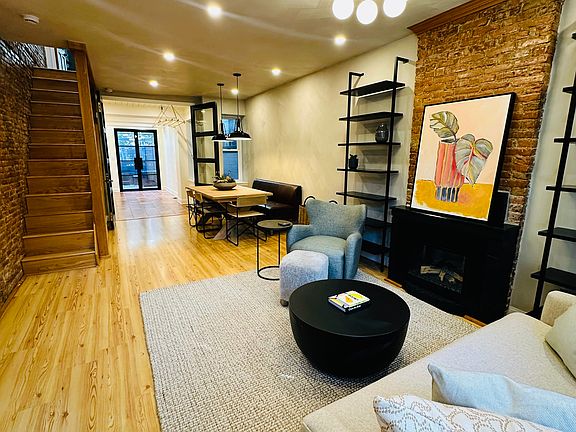Living room with electric fireplace through to dining area, kitchen, and back patio