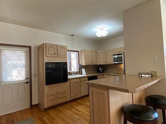 Fully equipped kitchen with breakfast bar, door leads to deck