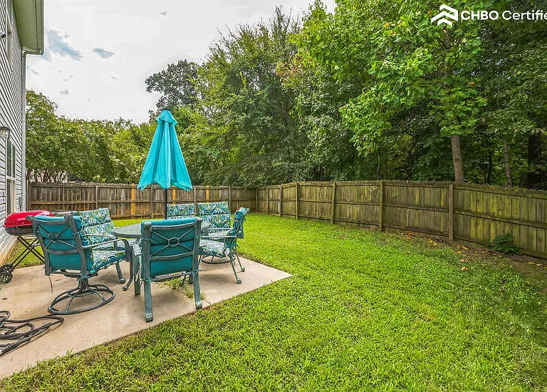 Large fenced yard with patio set.