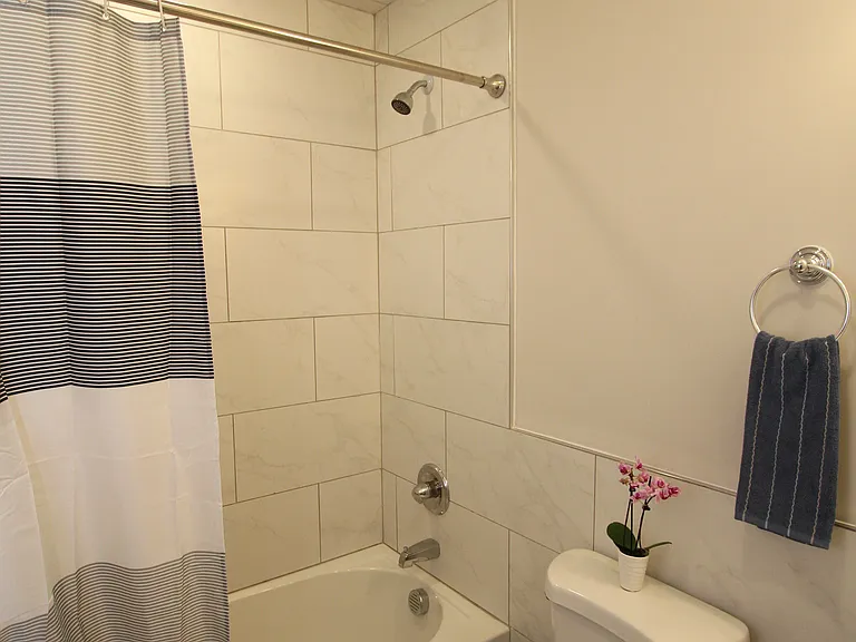 Relaxing full bathroom with a tiled tub and shower for added comfort and convenience