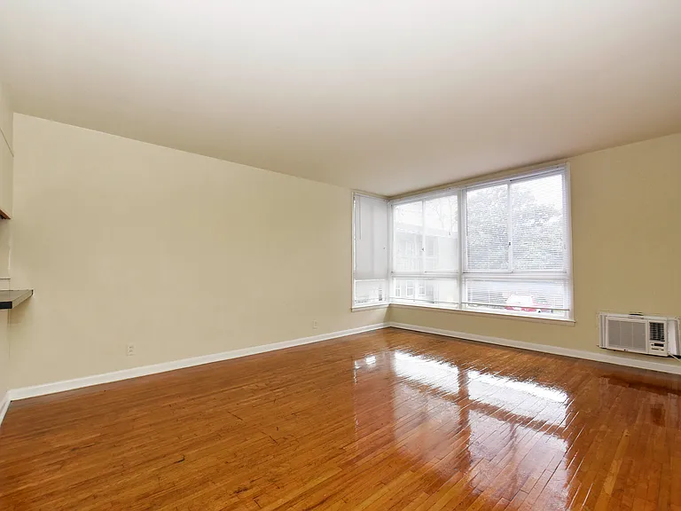 Experience the warmth of natural light across elegant hardwood floors in this inviting living area.