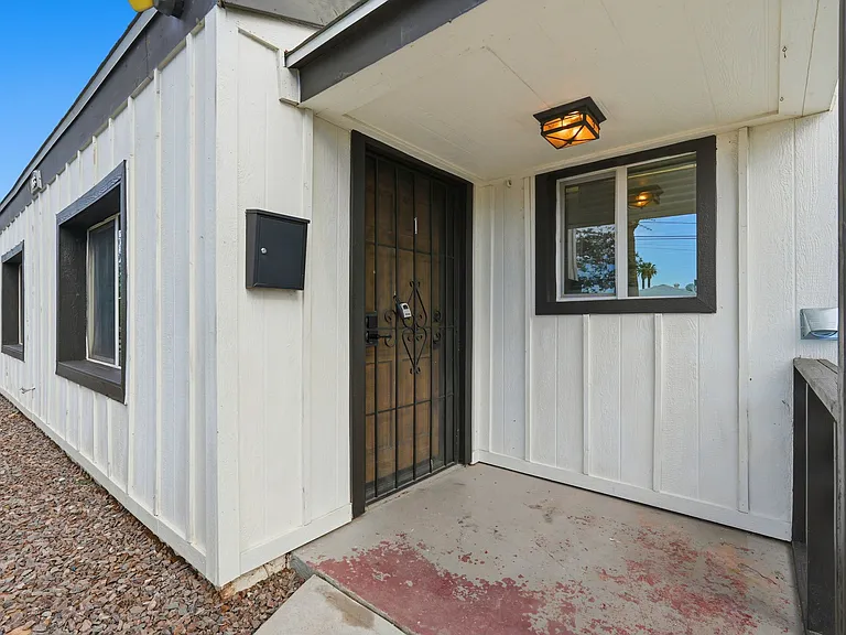 Covered patio at front entrance with security door.