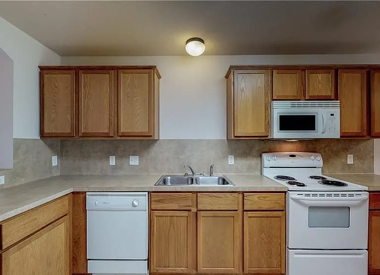 Modern kitchen with Stainless steel double sinks, Electric oven and built in microwave. Dishwasher and garbage disposal. This unit also has full sized washer and dryer