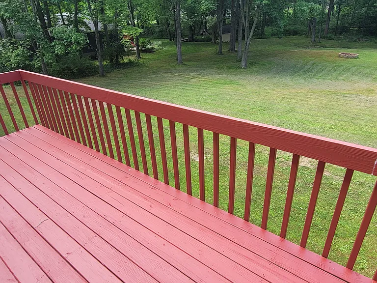 The view from the balcony looks out over the entire 1.1-acre lot, framed by a beautiful, private wooded backdrop.